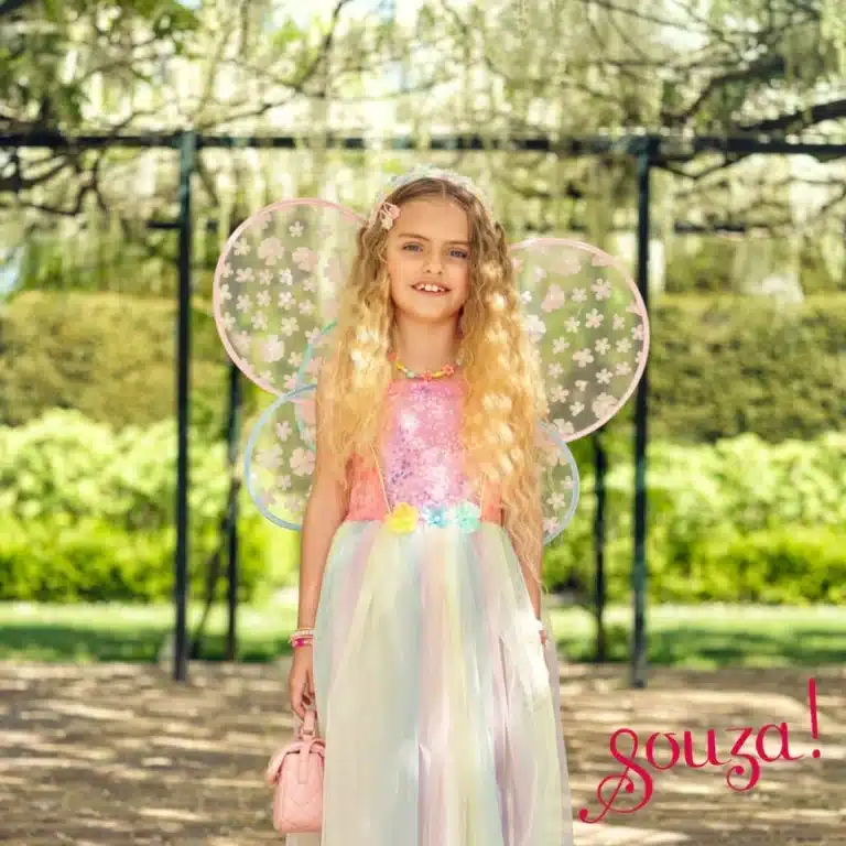 Meisje draagt een Souza prinsessenjurk, de Flora-jurk met regenboogrok en transparante bloemenvleugels.