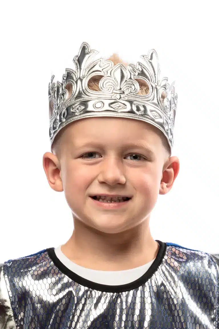 Jongen draagt de glanzend zilveren Little Adventures ridderkroon uit een ridder verkleedset; het zilveren kostuum is zichtbaar.