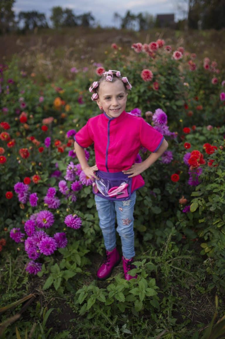 Kind draagt het roze Great Pretenders make-upartiestenset in maat 5-6 jaar, met paarse tailleband en transparante zakken