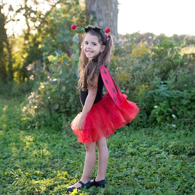 Meisje dat een lieveheersbeestje kostuum draagt