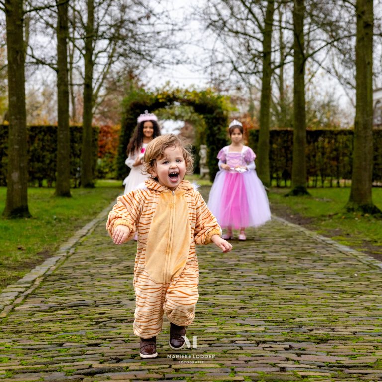 Jongetje die rent in een tijger onesie